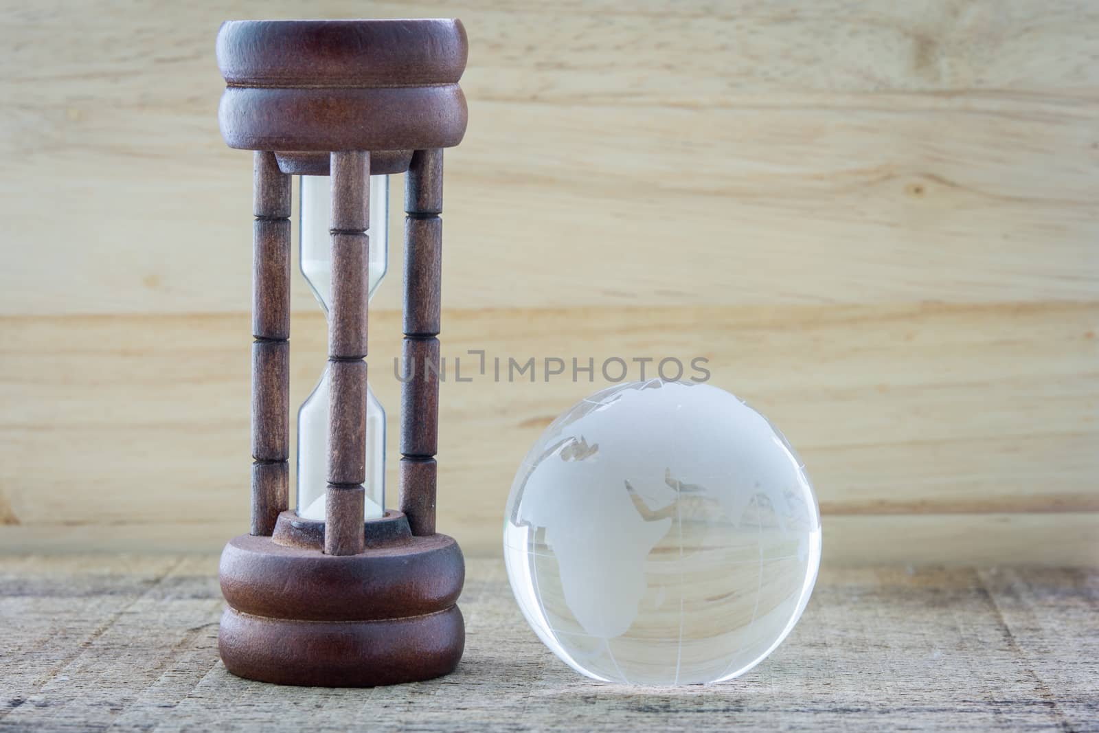 Wood hourglass countdown the Earth on wooden background
