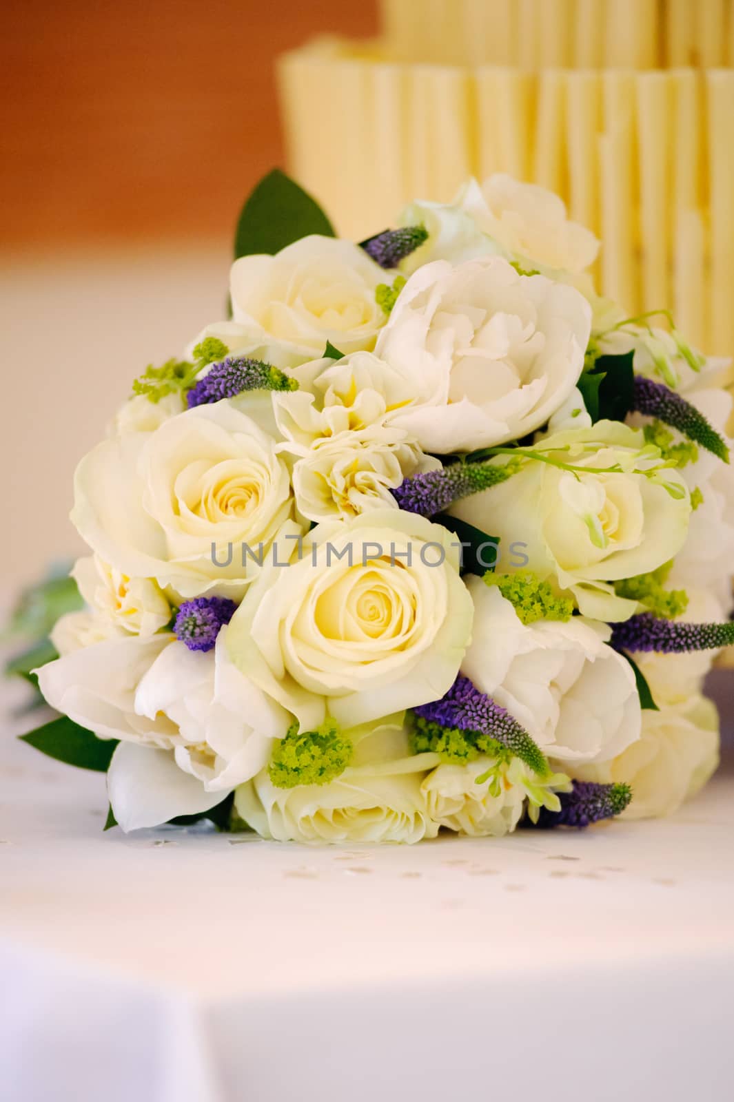 Yellow roses decorate cake table at wedding
