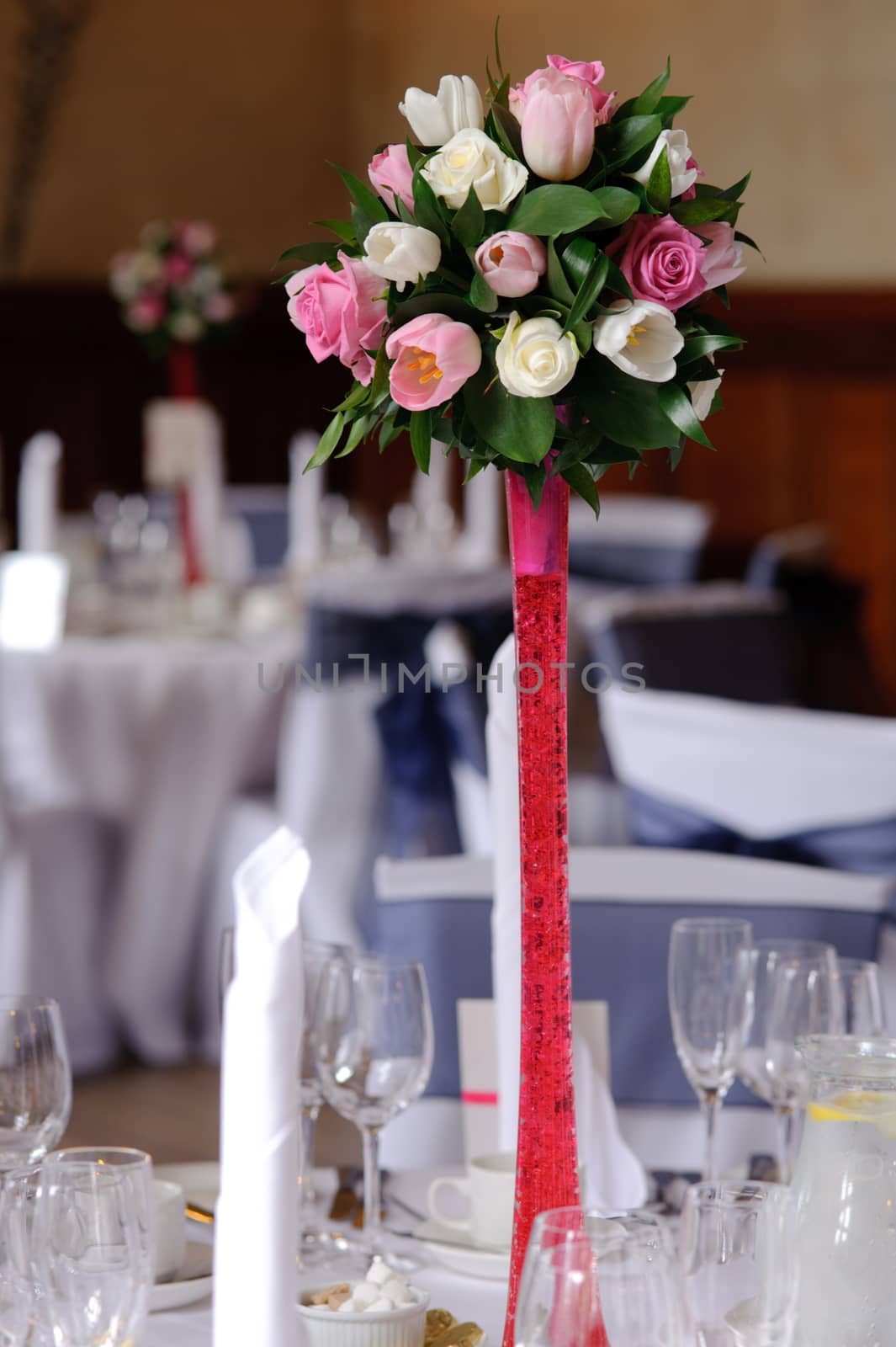 Wedding flowers on red stand at the reception