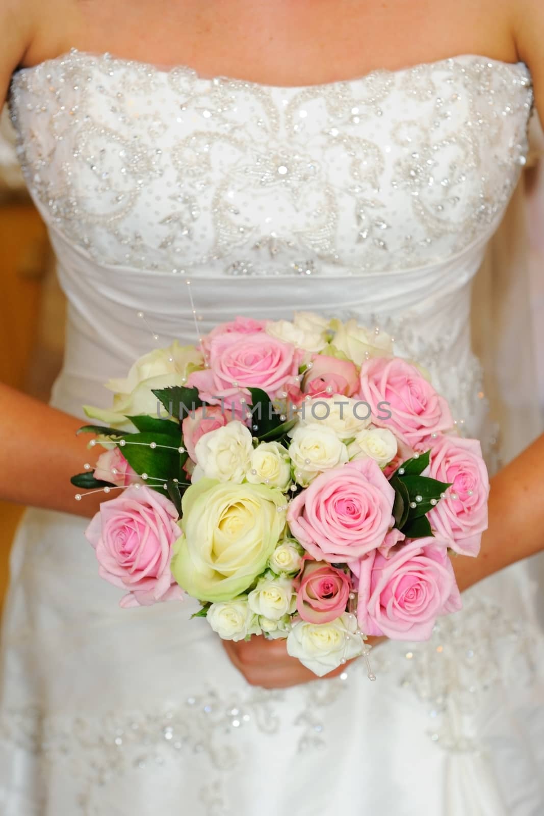 Close up of brides dress and bouquet at wedding