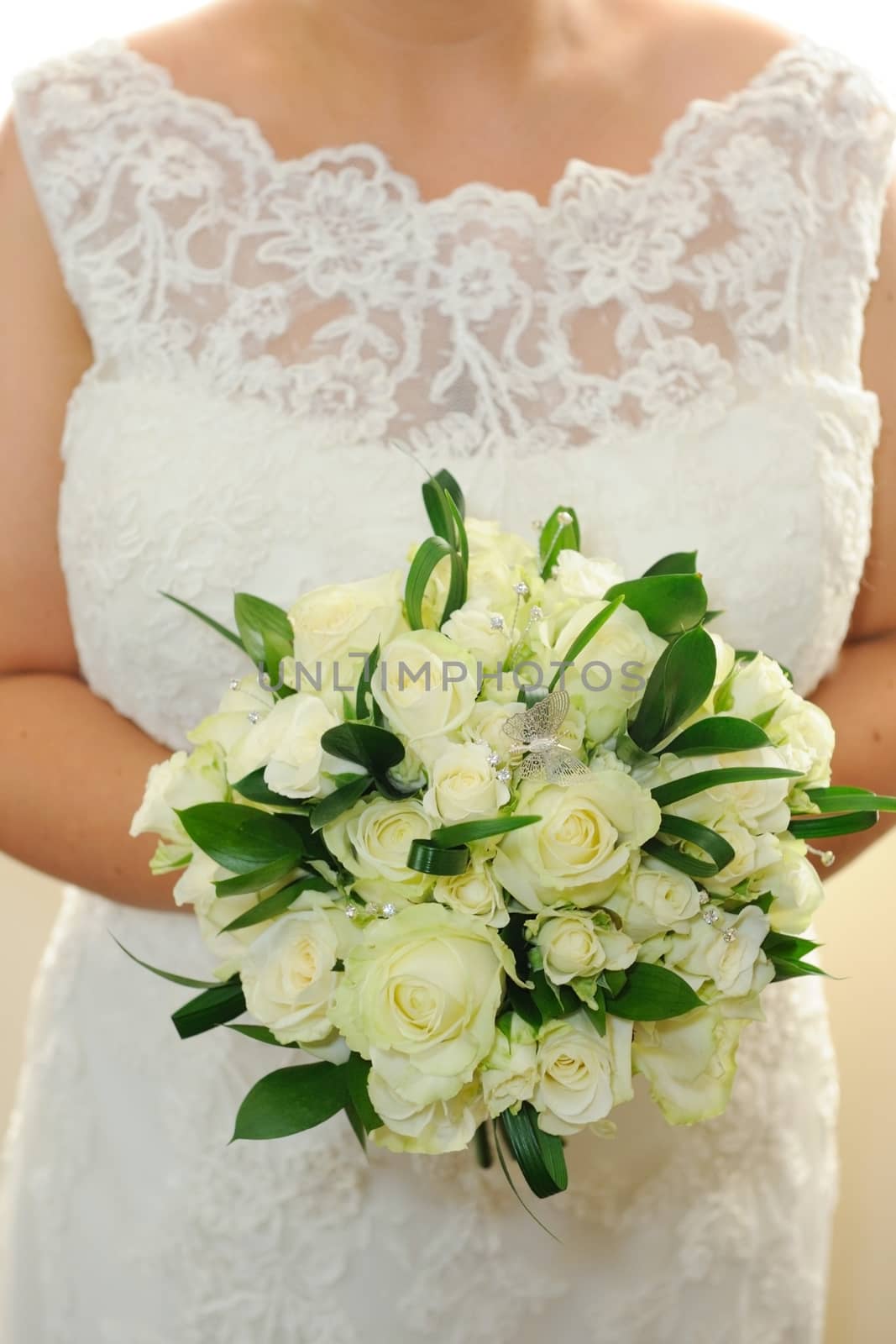 Closeup of bride bouquet and dress detail