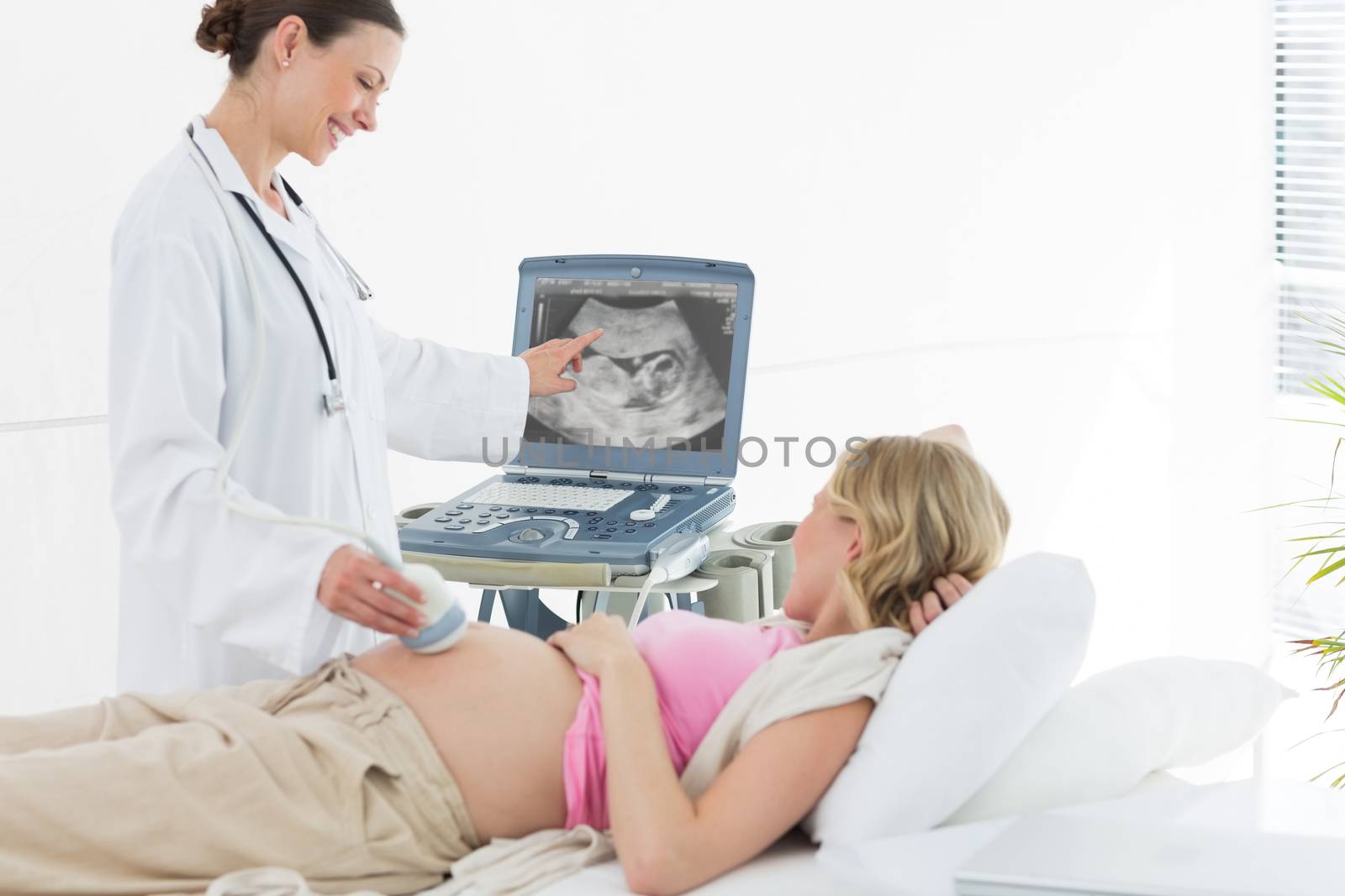 Doctor performing ultrasound by Wavebreakmedia