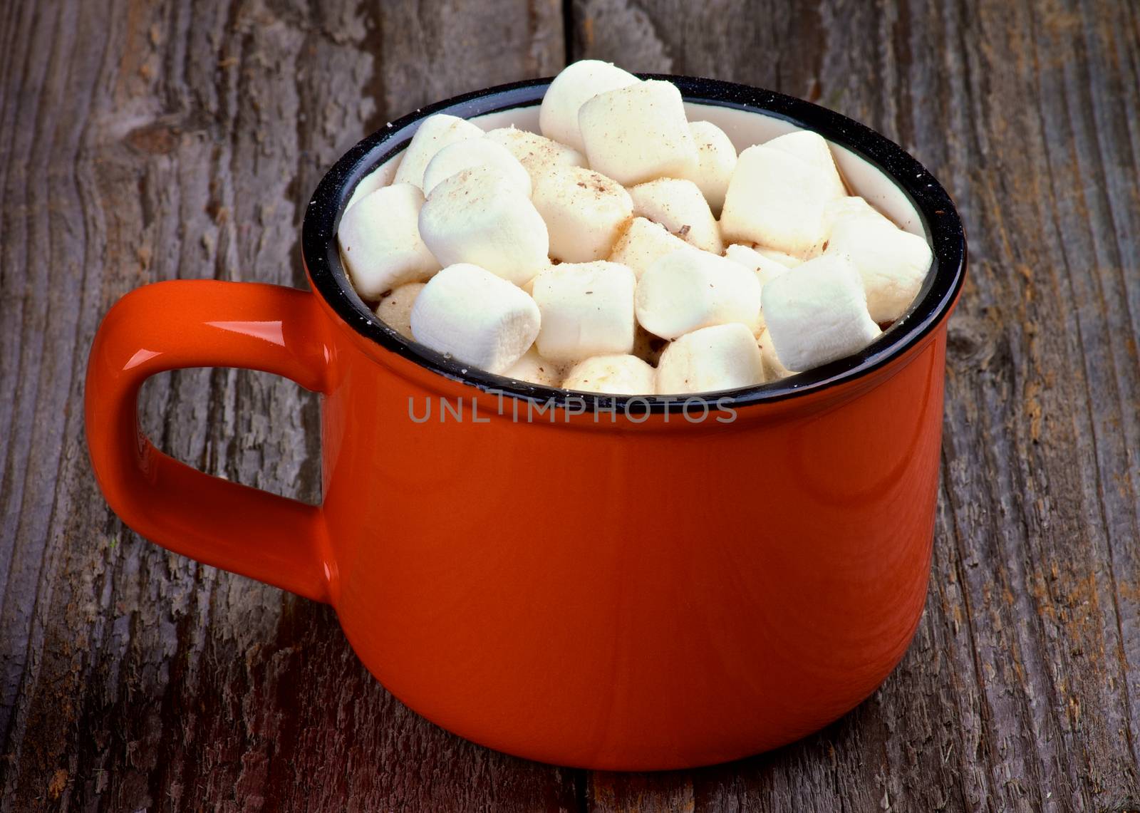 Hot Chocolate in Orange Cup with Marshmallows on Rustic Wooden background