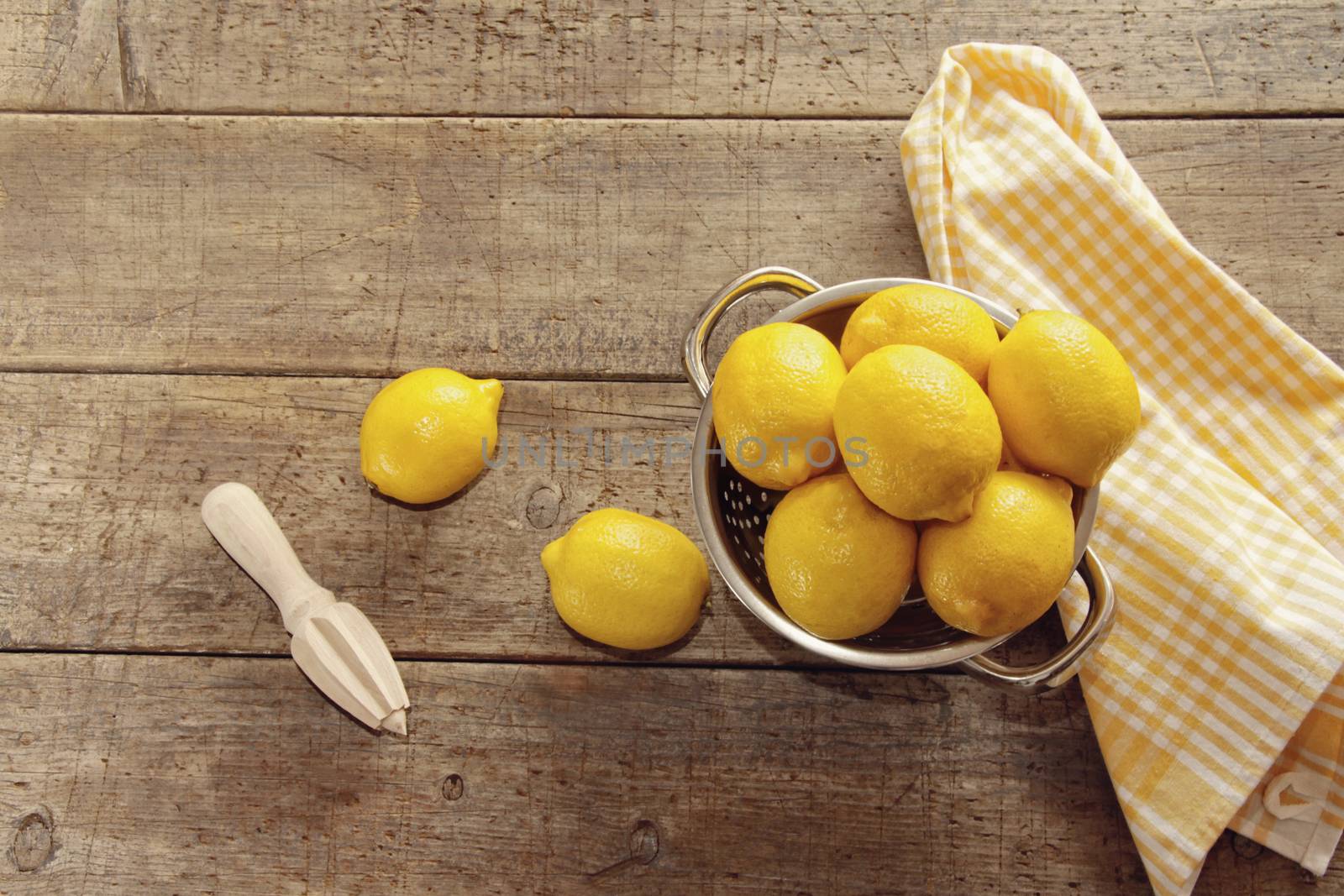 Fresh lemons on wooden counter by Sandralise