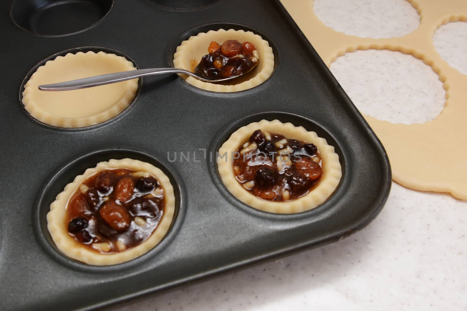 Filling mince pies with mincemeat, pastry scraps beyond