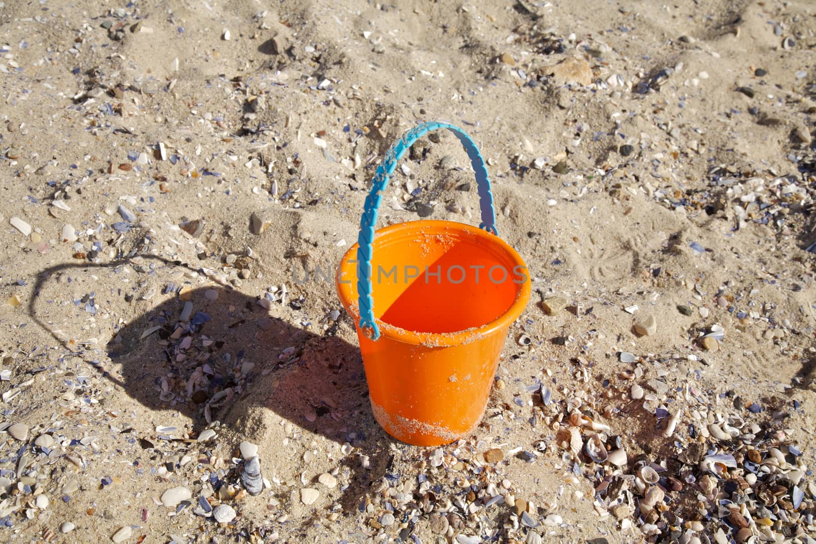 Child's beach bucket in the sand