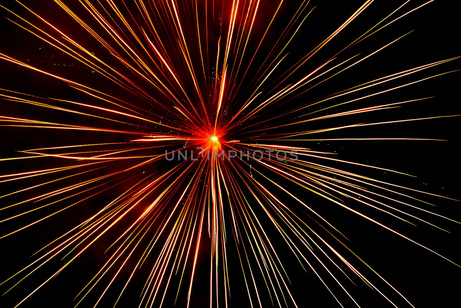 Lines of light rising from the middle of the fireworks.