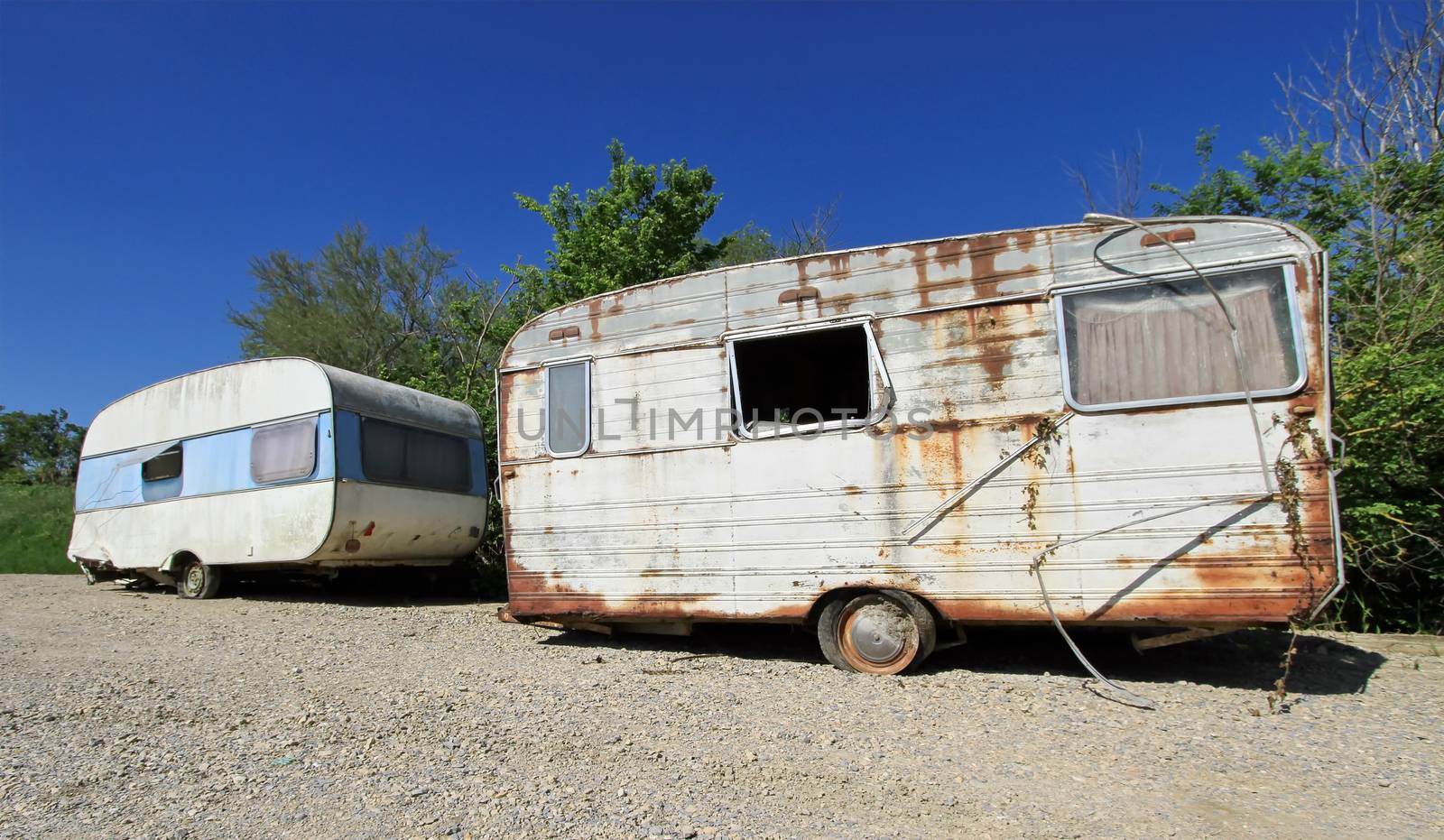 Two old decayed and abandoned caravan in nature