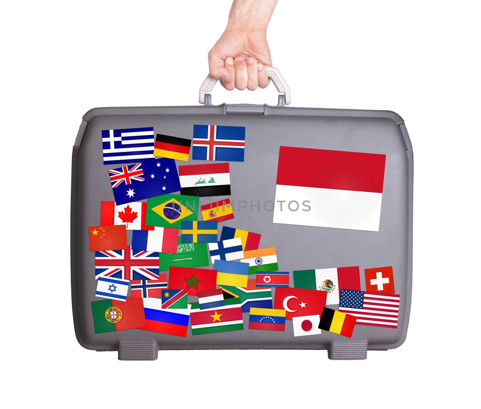 Used plastic suitcase with lots of small stickers, large sticker of Monaco