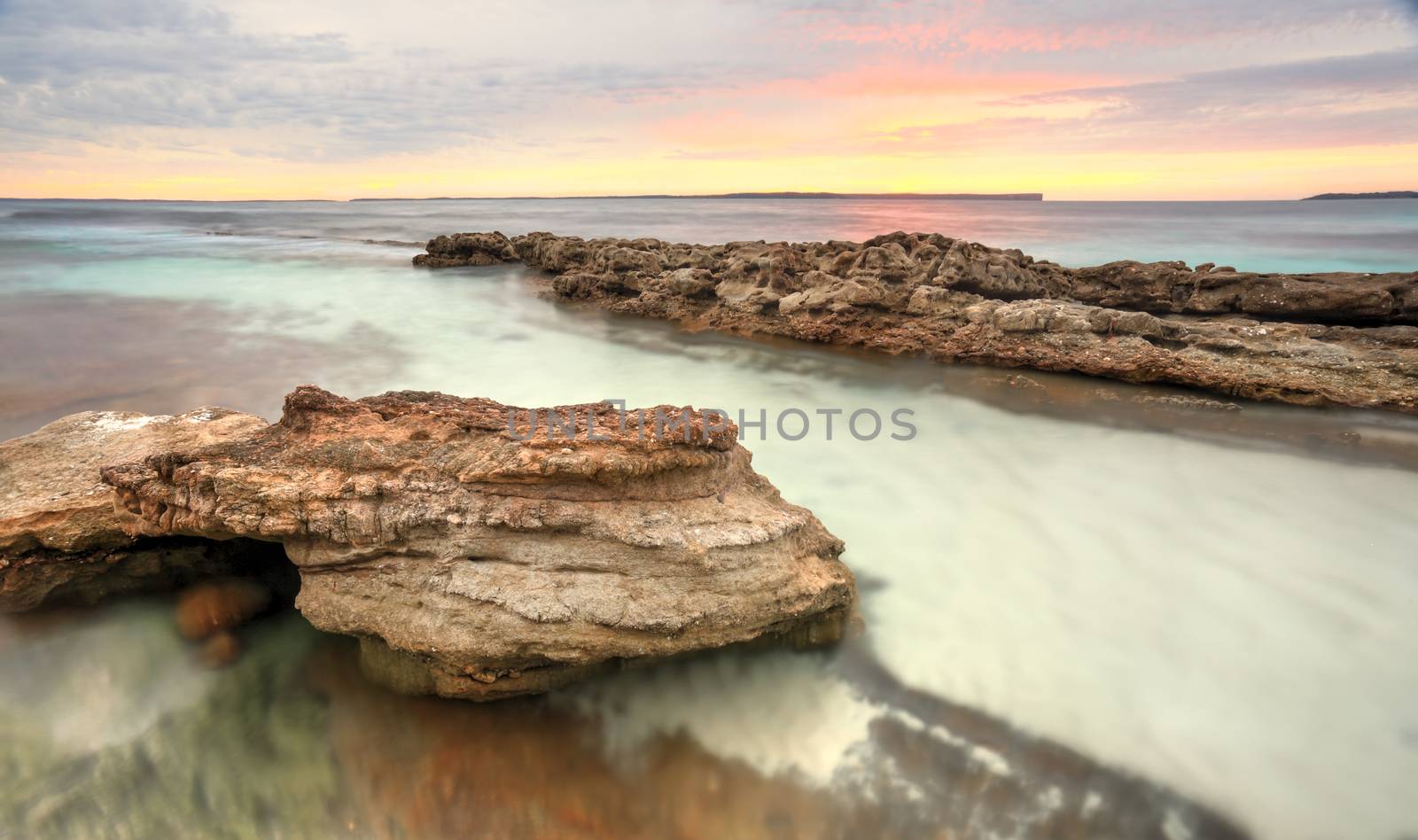 Pastel colours of a surreal sunrise at Hyams Beach at Jervis Bay, Australia.  Long exposure