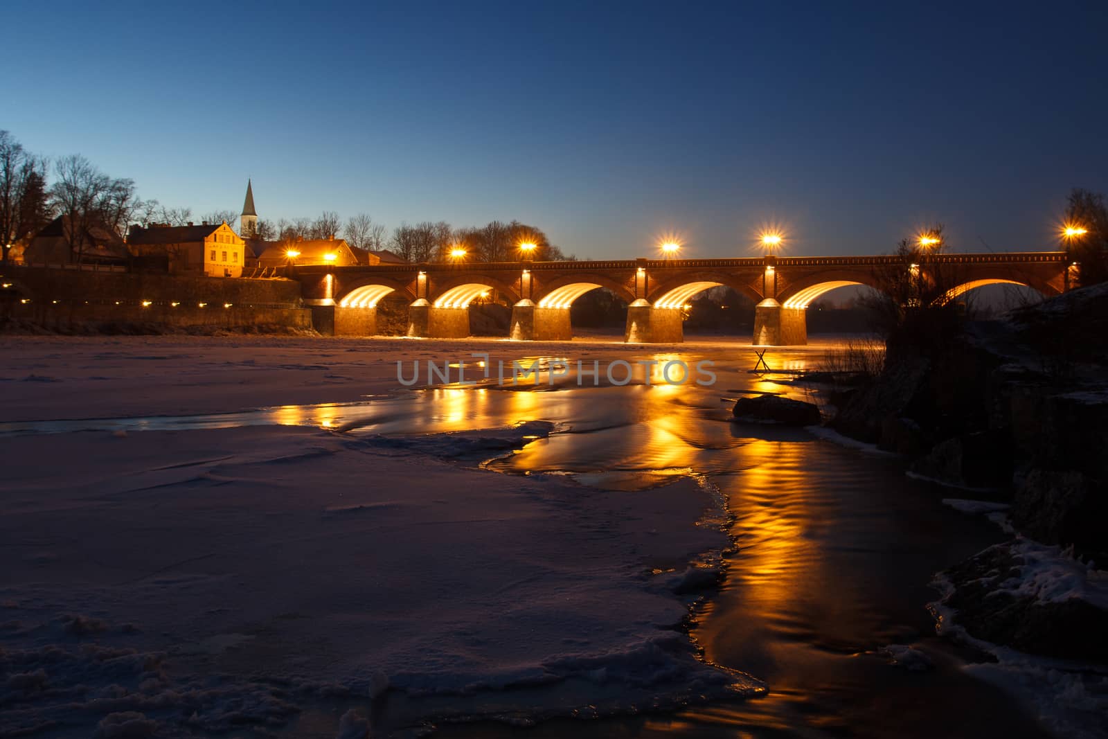 Frozen river Venta and old brick bridge in Kuldiga, Latvia