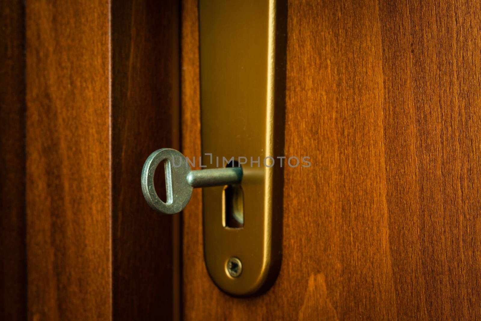 close-up key in keyhole of wooden door