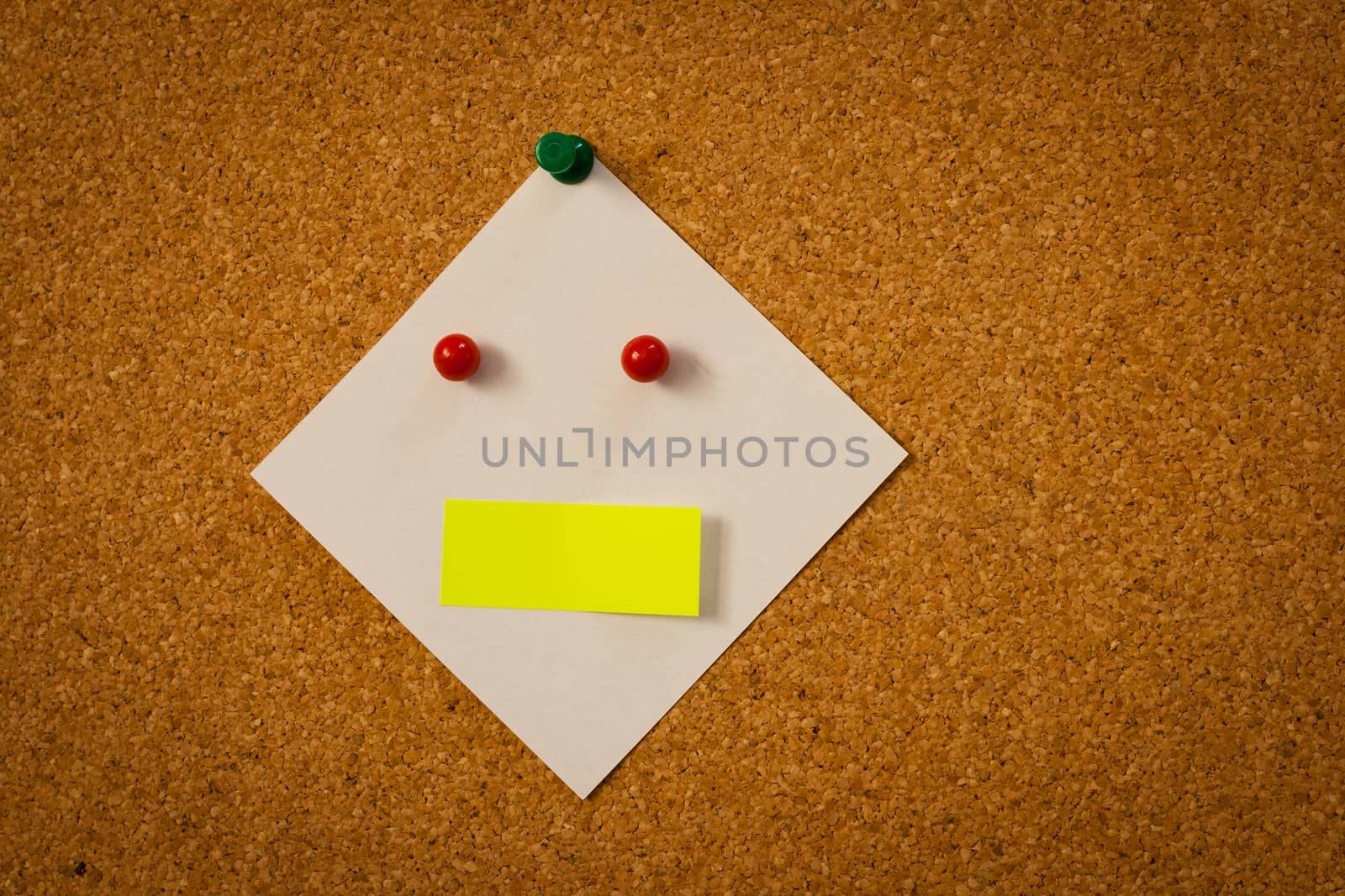 image of white blank post-it reminder as a face on corkboard