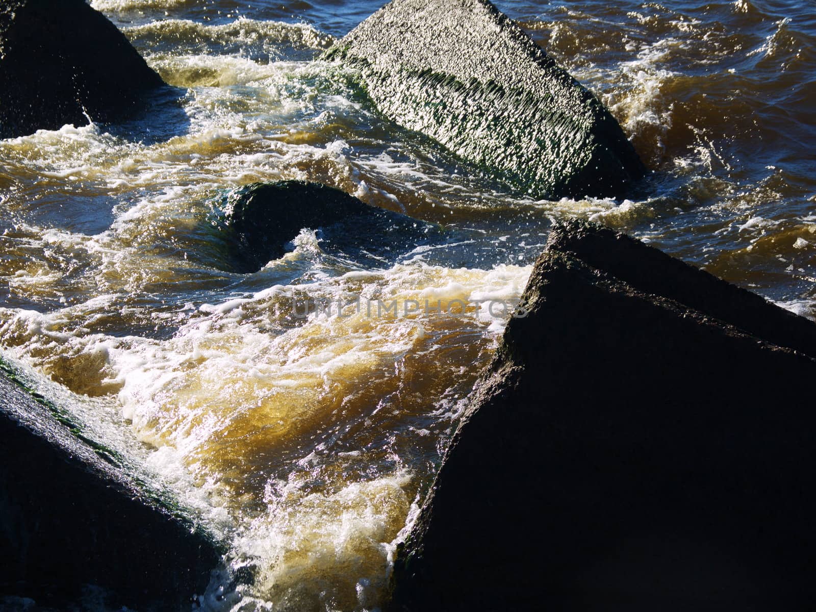 Clear sea water and the big stones surrounded with waves