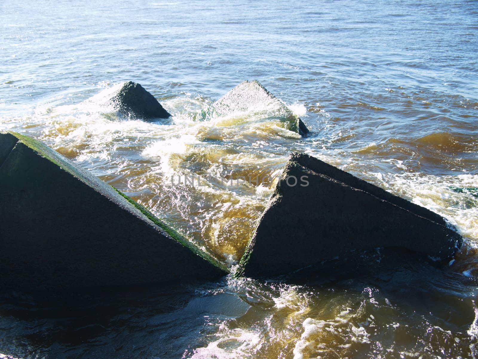 Clear sea water and the big stones surrounded with waves