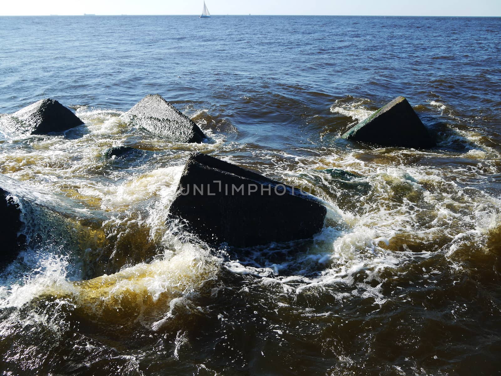 Clear sea water and the big stones surrounded with waves