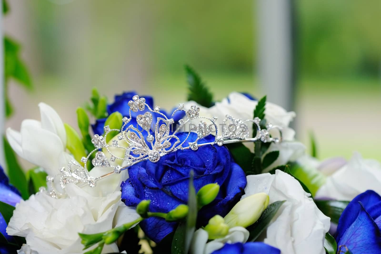 Brides shiny tiara on blue rose bouquet