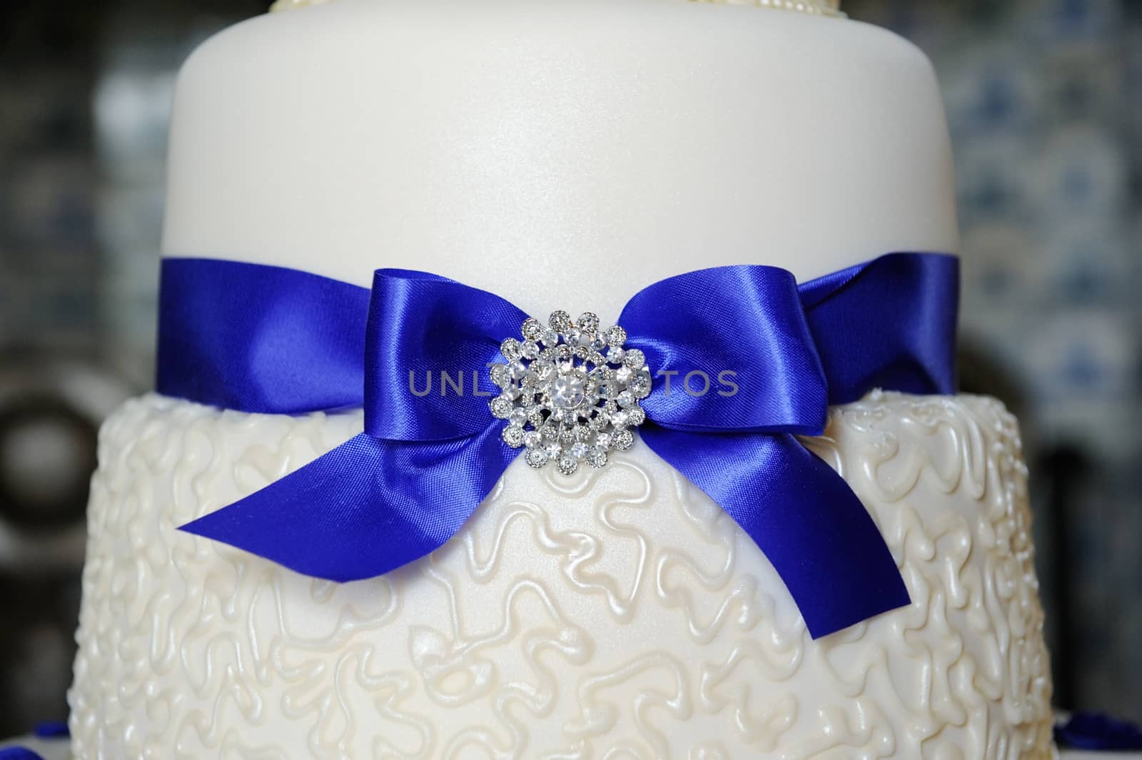 Blue ribbon decorates wedding cake at reception