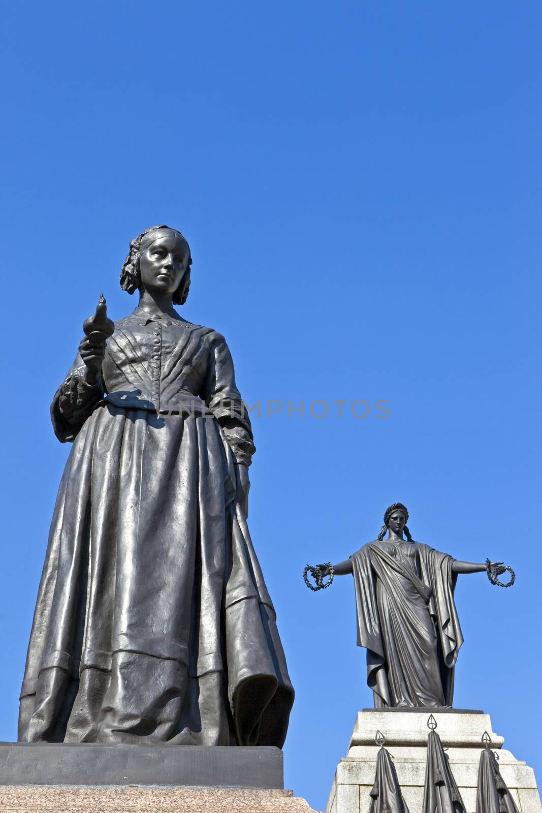 Florence Nightingale statue with the Crimean War Memorial behind.  Situated in Waterloo Place in London.