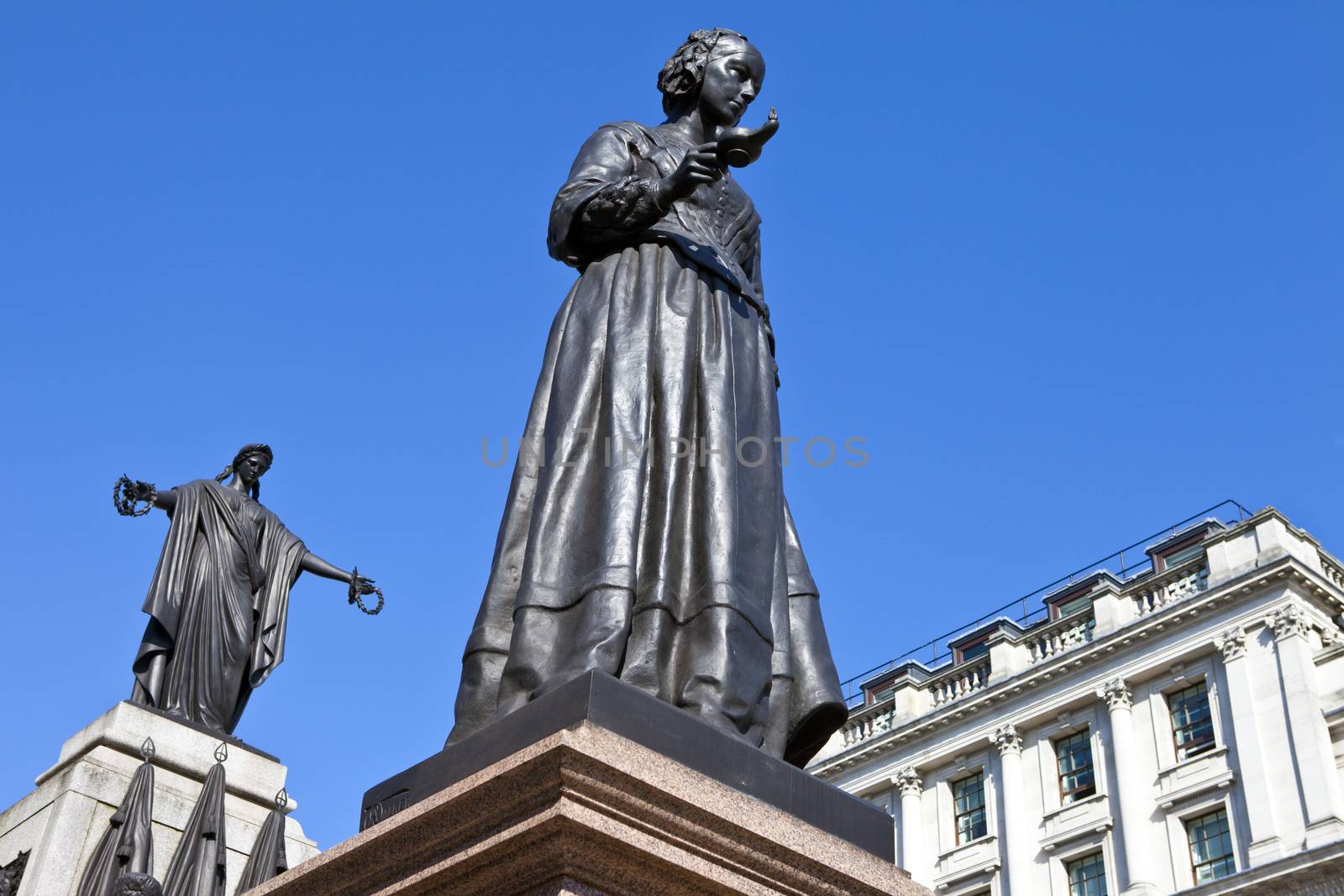 Florence Nightingale statue with the Crimean War Memorial behind.  Situated in Waterloo Place in London.