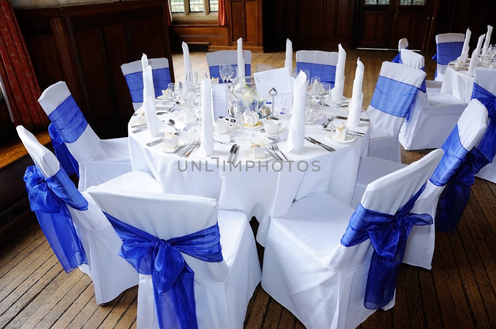 Table and chairs decorated in blue and white at wedding reception