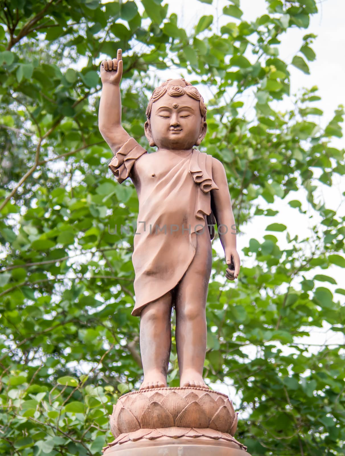 Image of concrete young Buddha in an asian garden