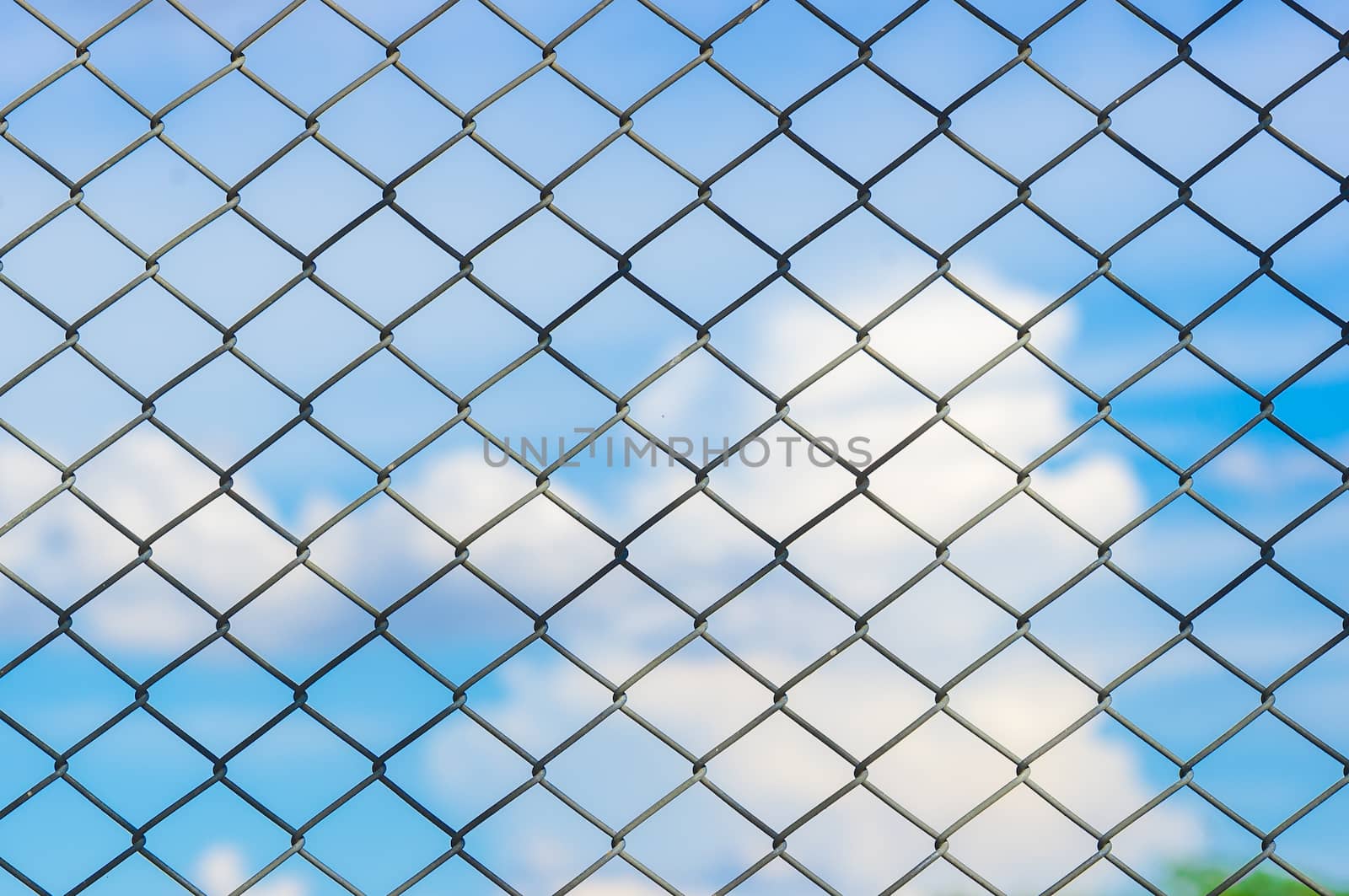 Metal mesh wire fence with blur cloud and blue sky background