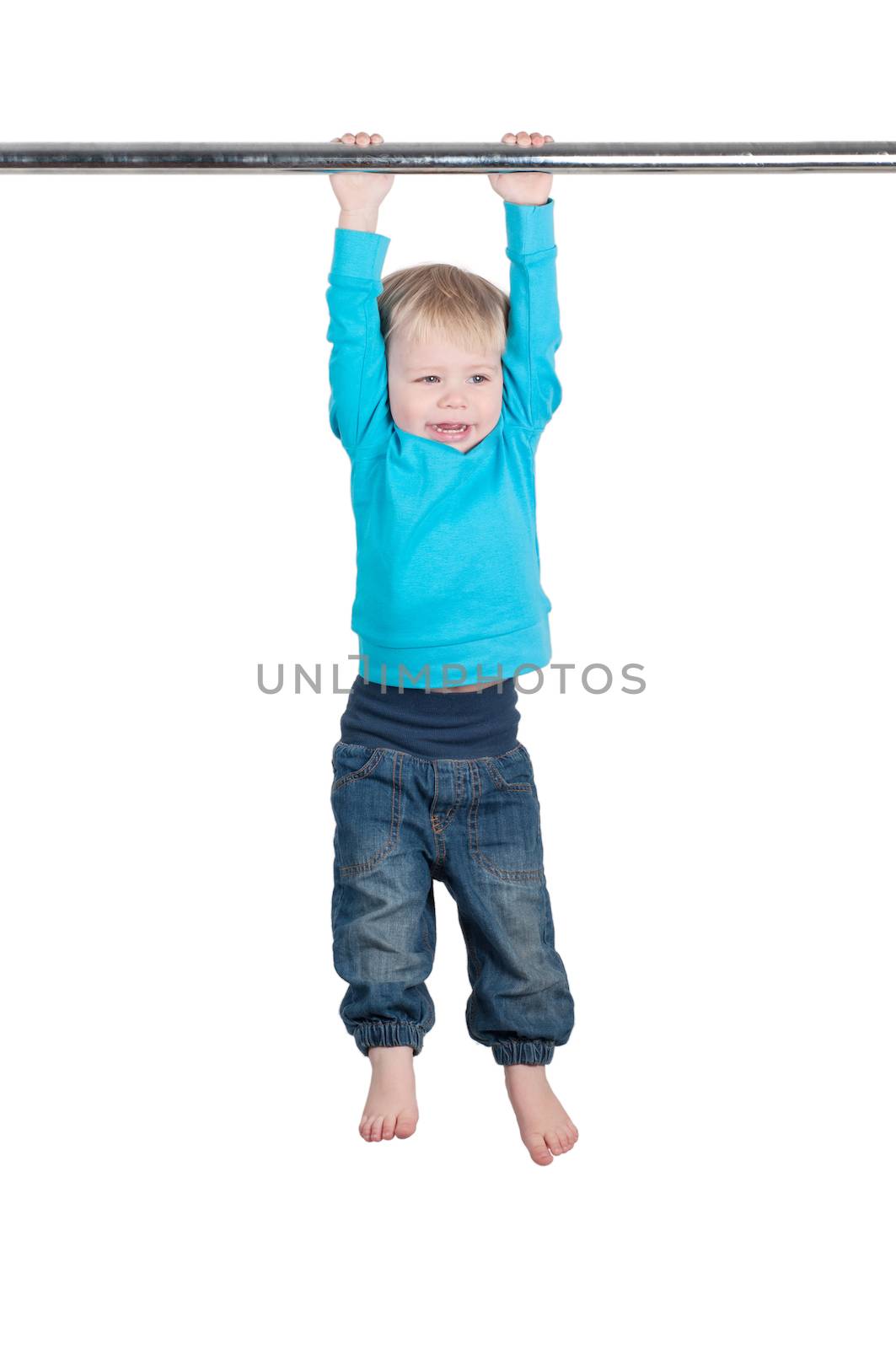 Portrait of a funny little boy hangs by horizontal bar
