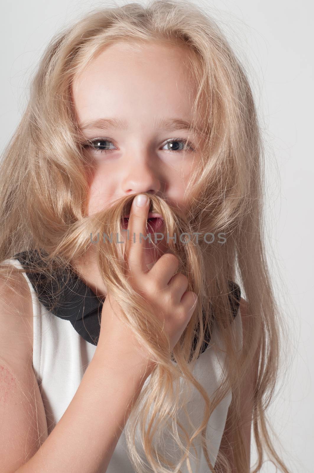 Little girl with long hair fooling around in studio