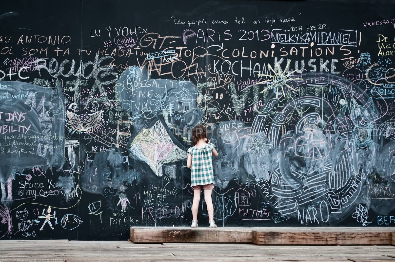 little girl writing on big blackboard