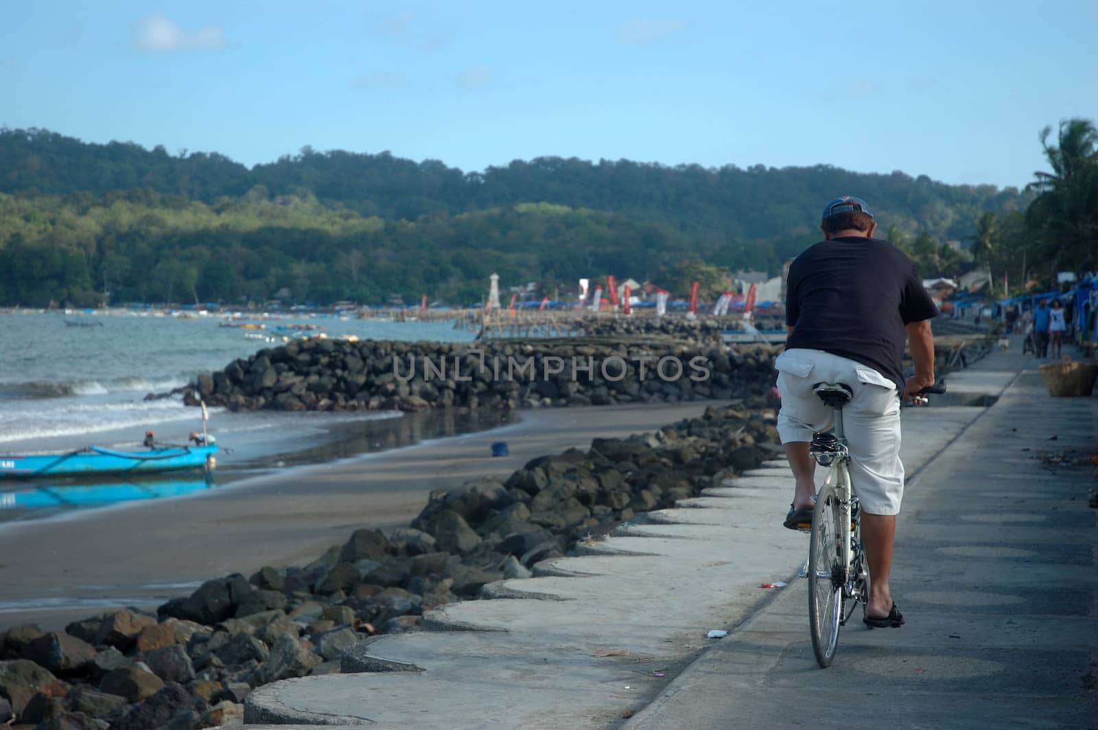 Pangandaran, Indonesia - July 16, 2011: Man riding a bike at Pangandaran beach shore, West Java-Indonesia.