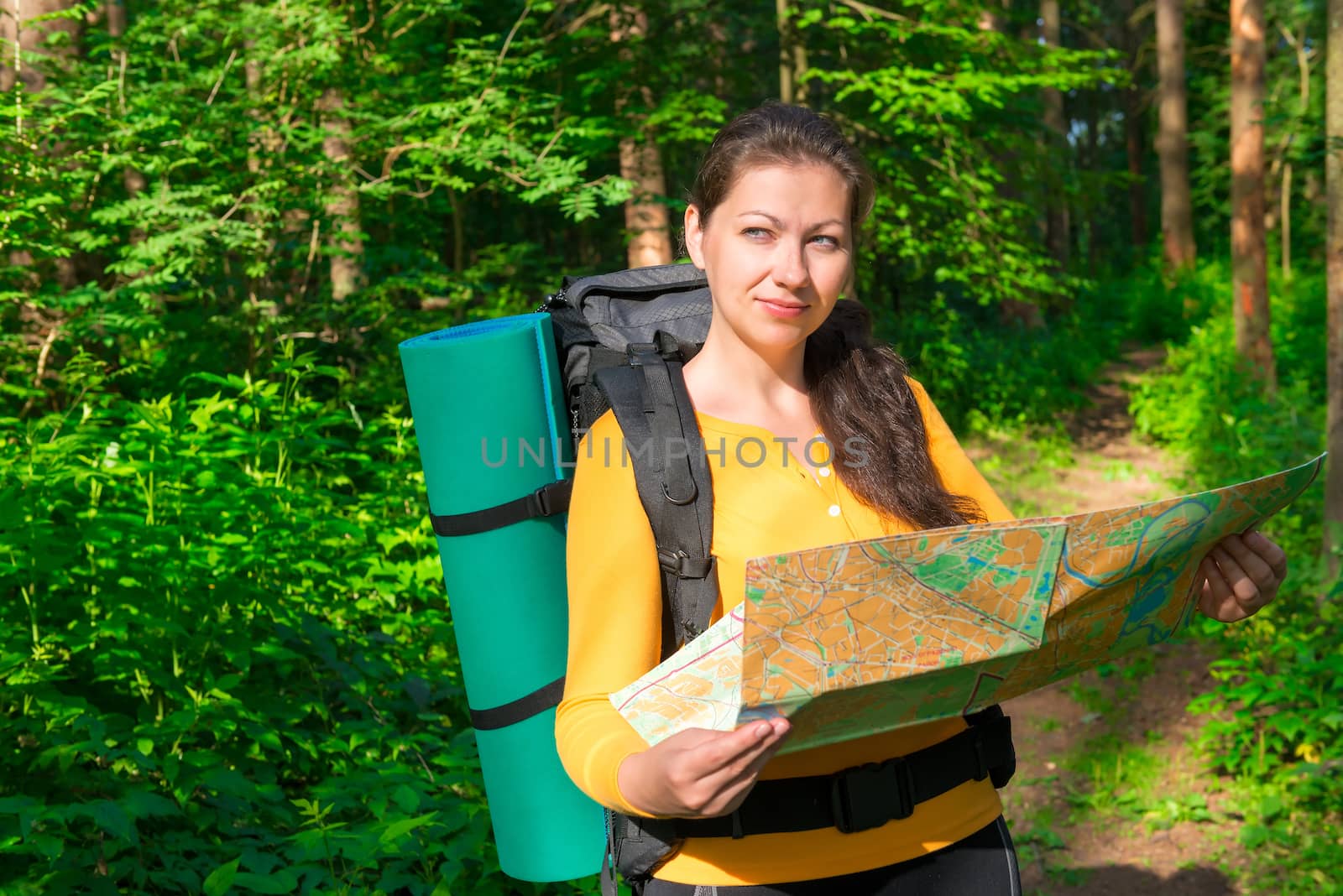 pensive tourist with map in a summer forest