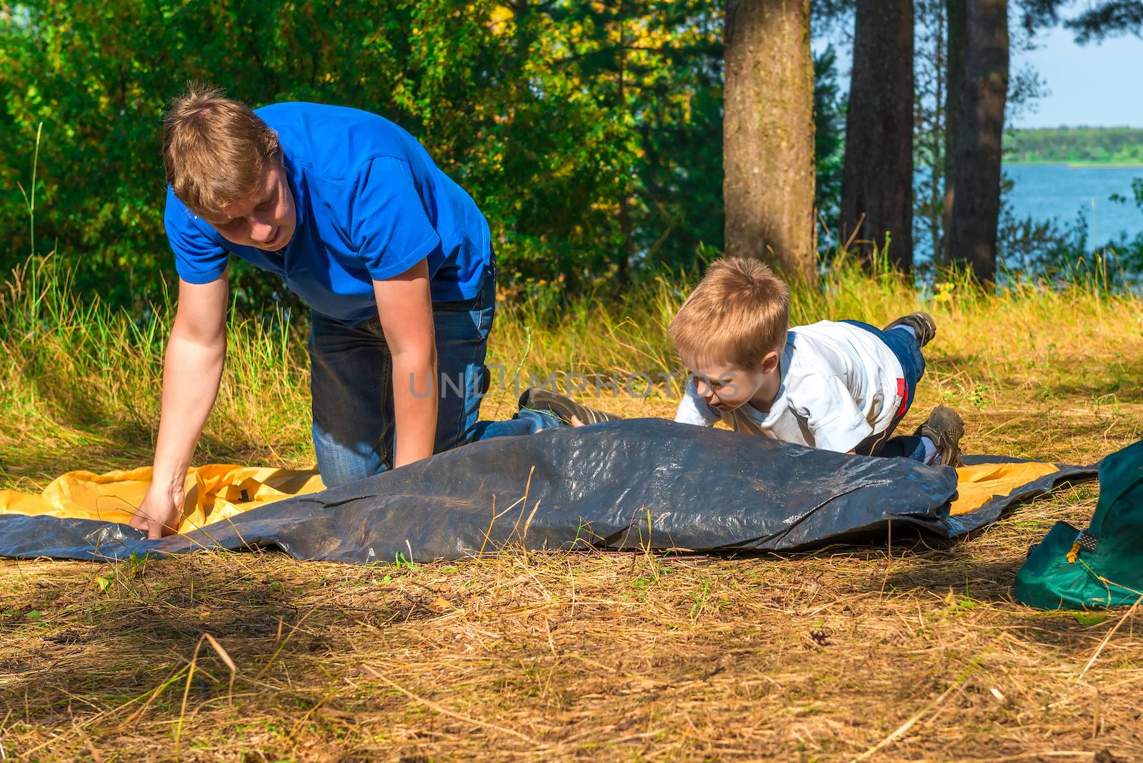 child with his father to install a tent
