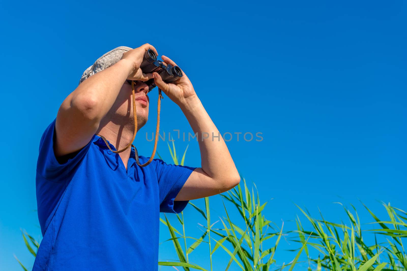 man with binoculars examines bird in the sky by kosmsos111