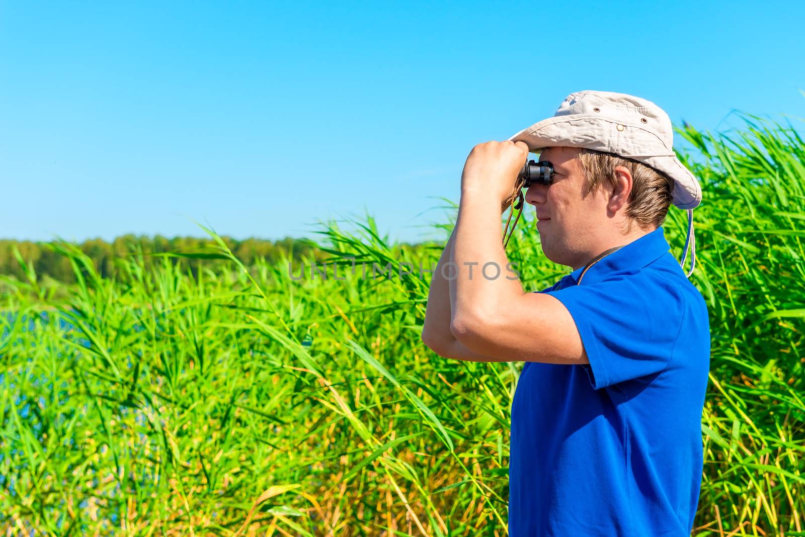 hunter with binoculars in the reeds by kosmsos111