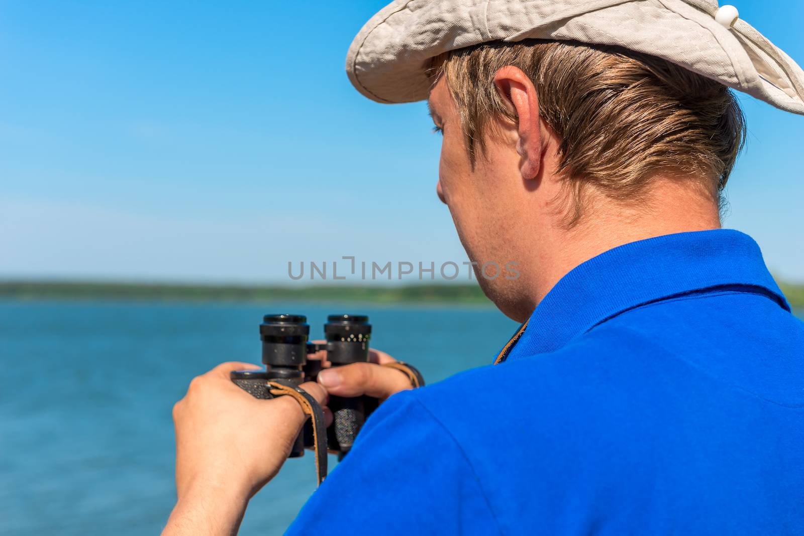 a young man with binoculars on the nature