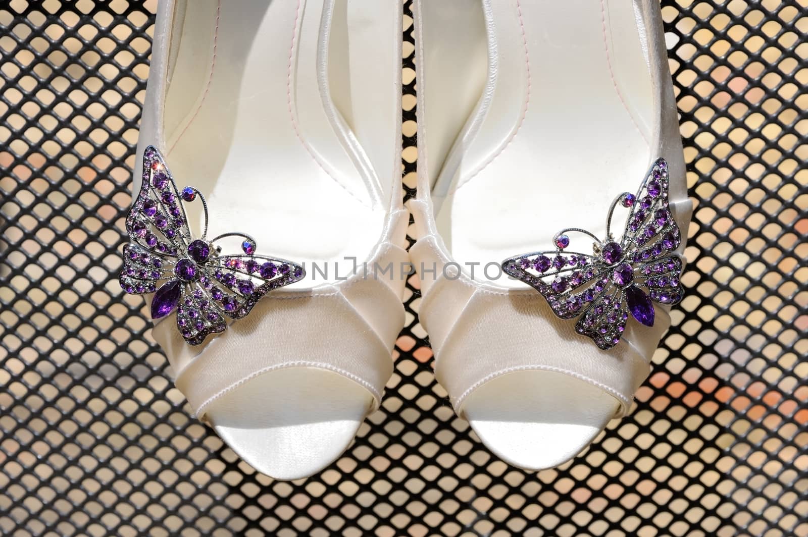 Brides shoes closeup show purple butterfly detail 