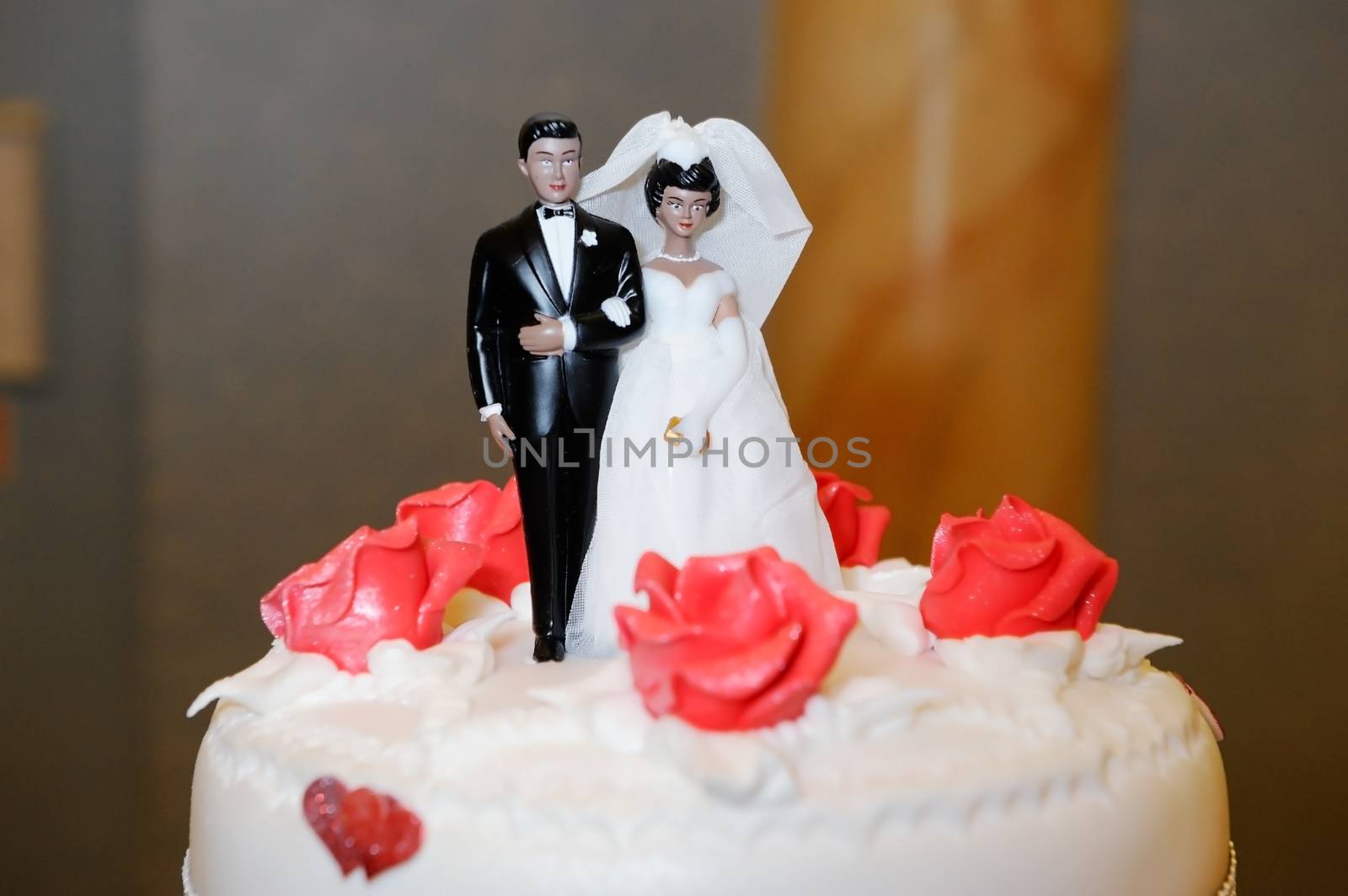 Ethnic Bride and groom decorate wedding cake