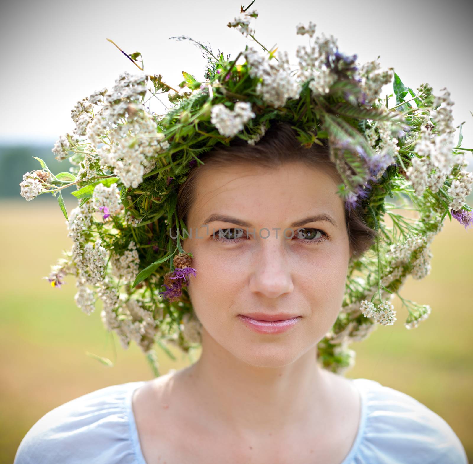 portrait of a young woman wearing a crown of summer wildflowers