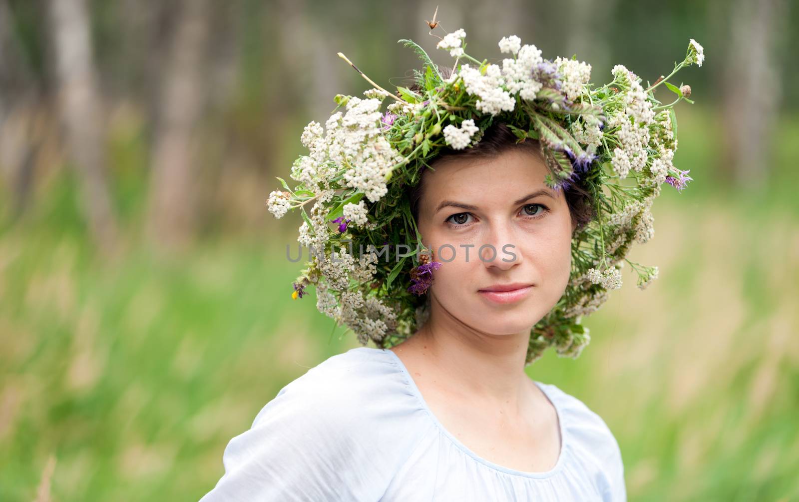 portrait of a young woman wearing a crown of summer wildflowers