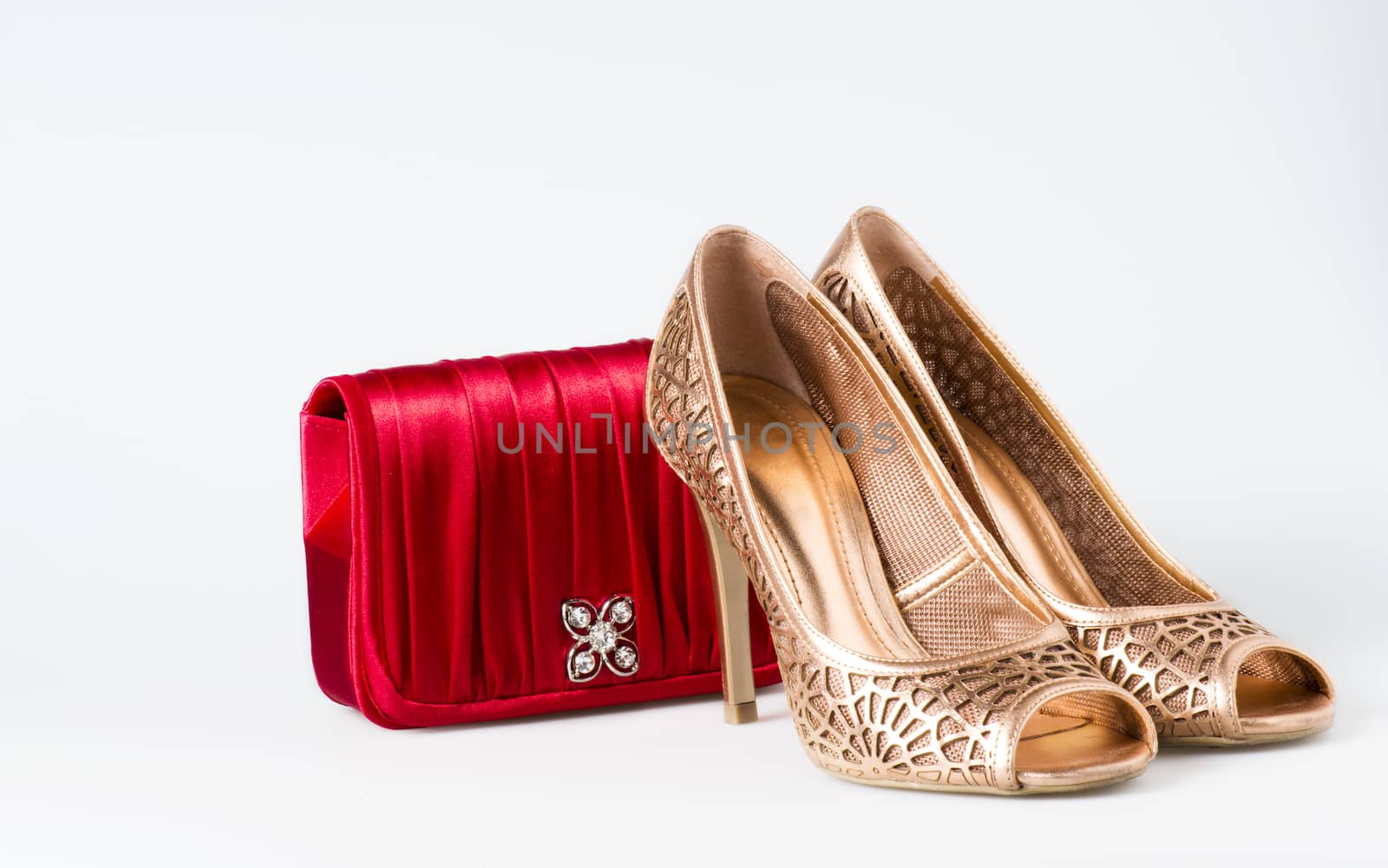 Woman gold shoes on white background whit red purse