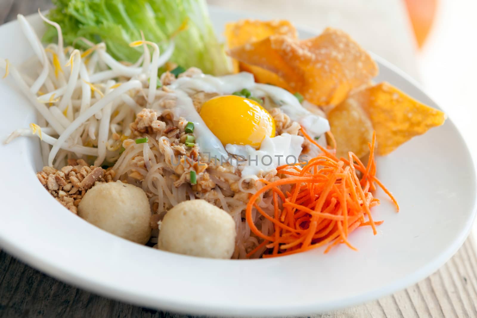 Gai pad bai gaprow style Thai dish with fried egg and rice noodles.