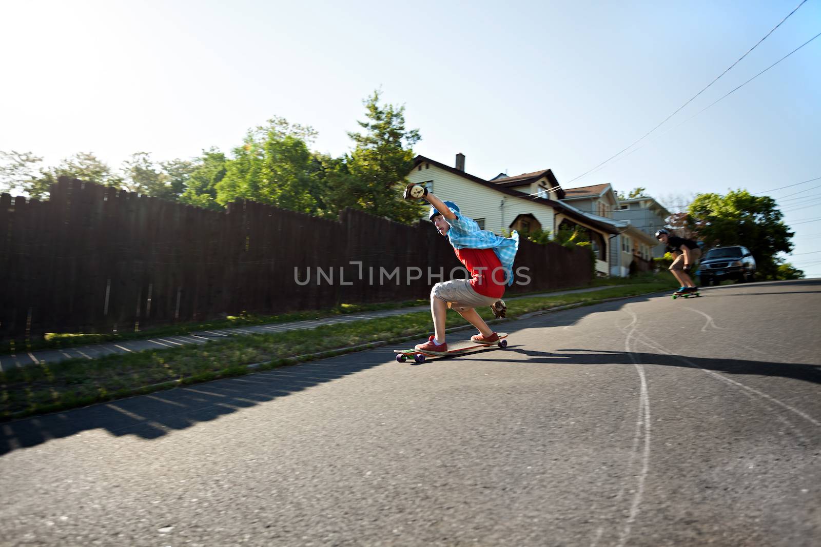 Long boarders skating on an urban road. Panning technique used with slight motion blur.  Sharpest focus on the closest skater.