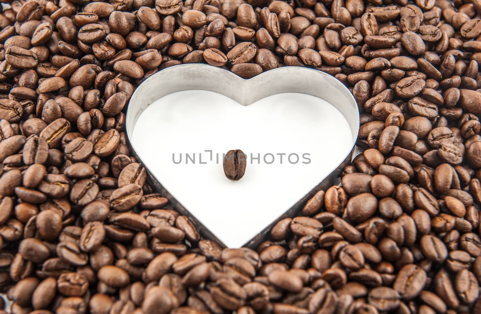 Coffee beans in the white heart surrounded by coffee beans.