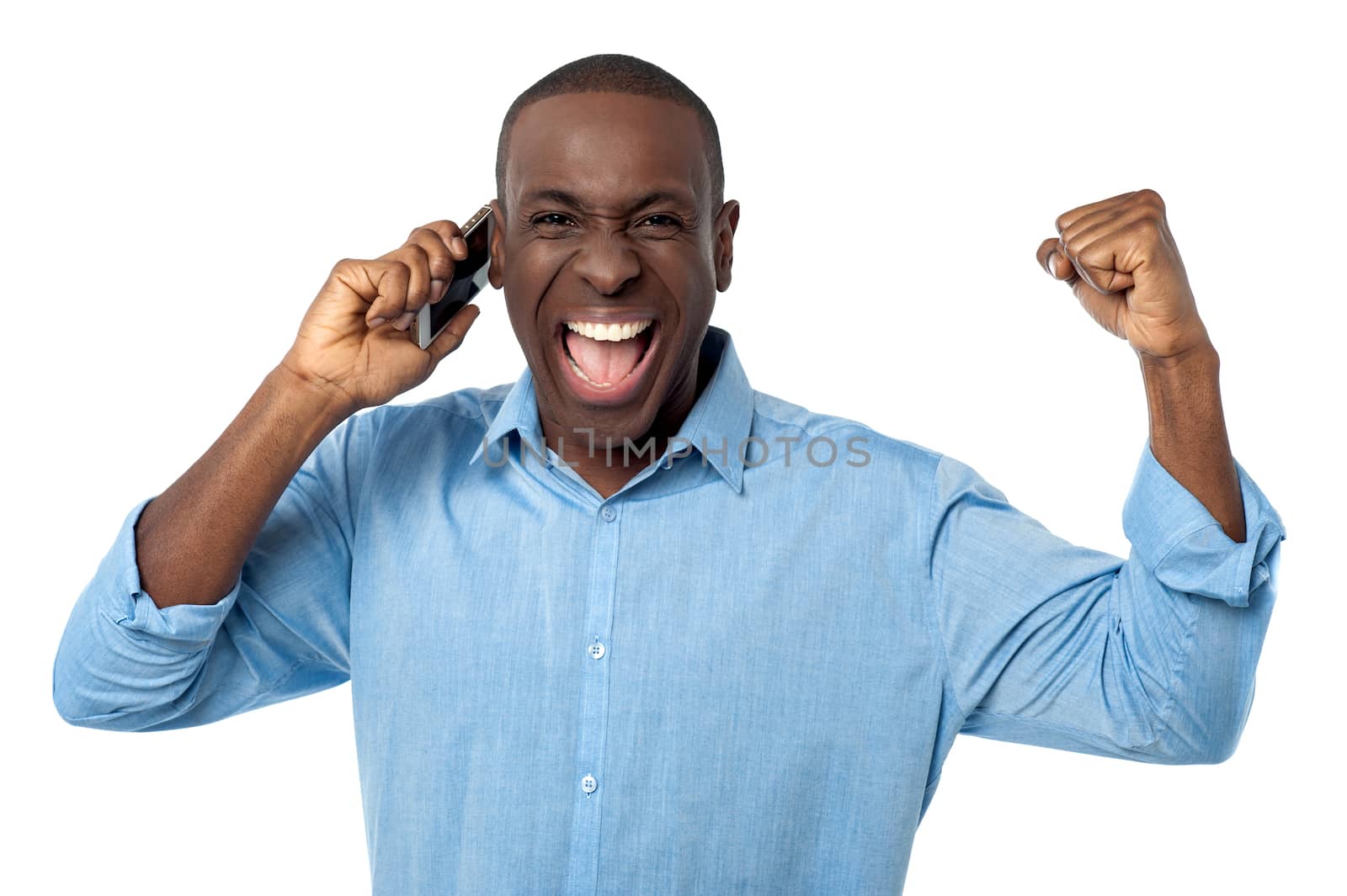 Happy man with cell phone, clenching fists in excitement