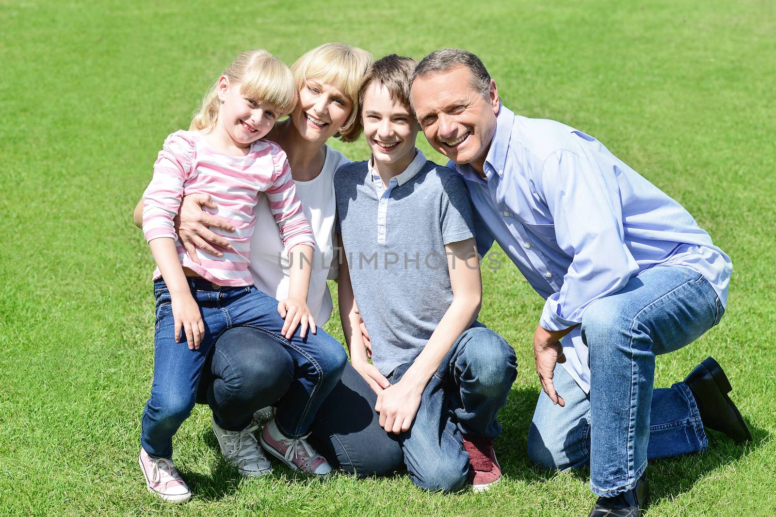 Lovable family posing in the park by stockyimages