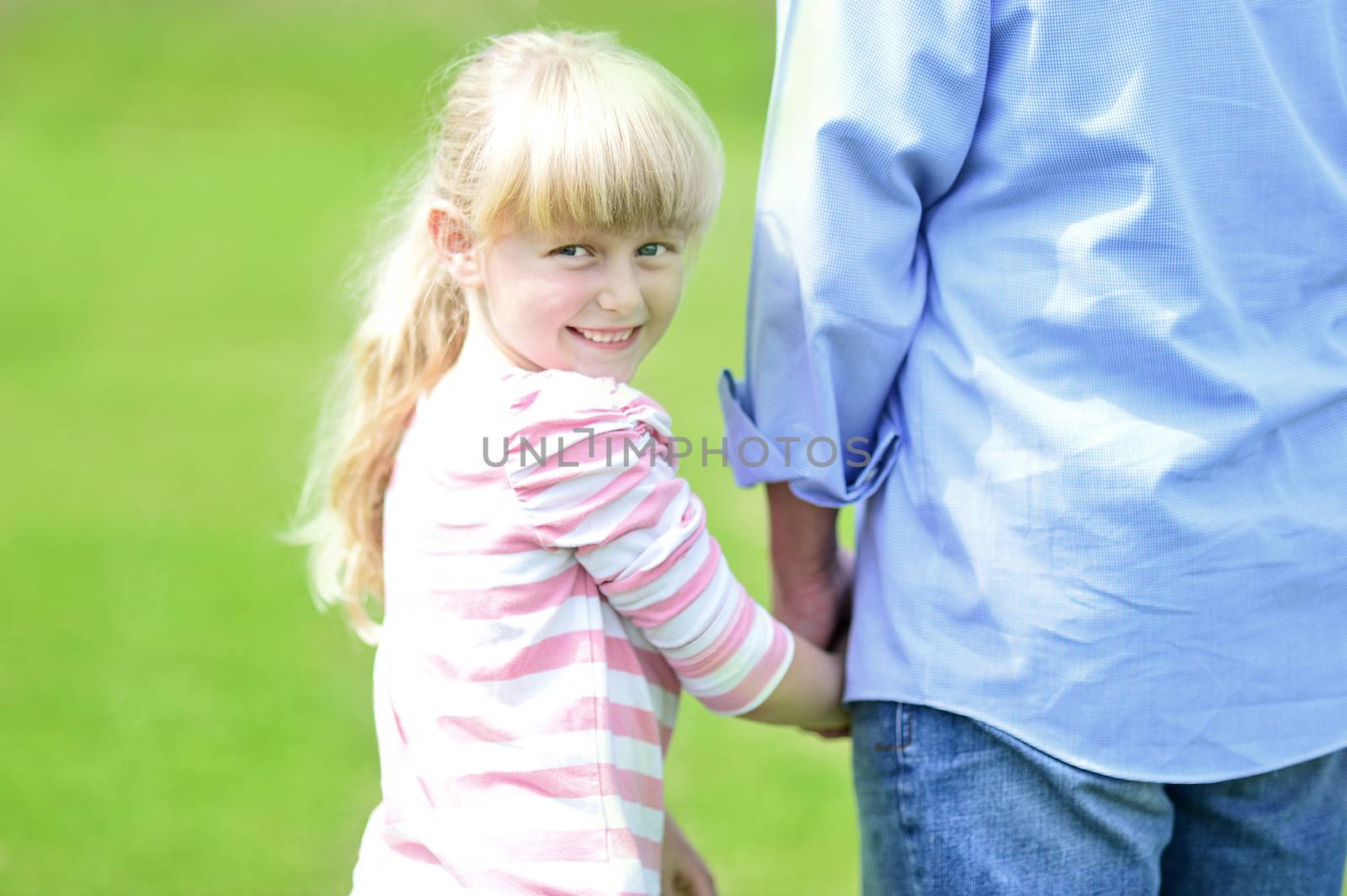 Cute little girl holding her father's hand