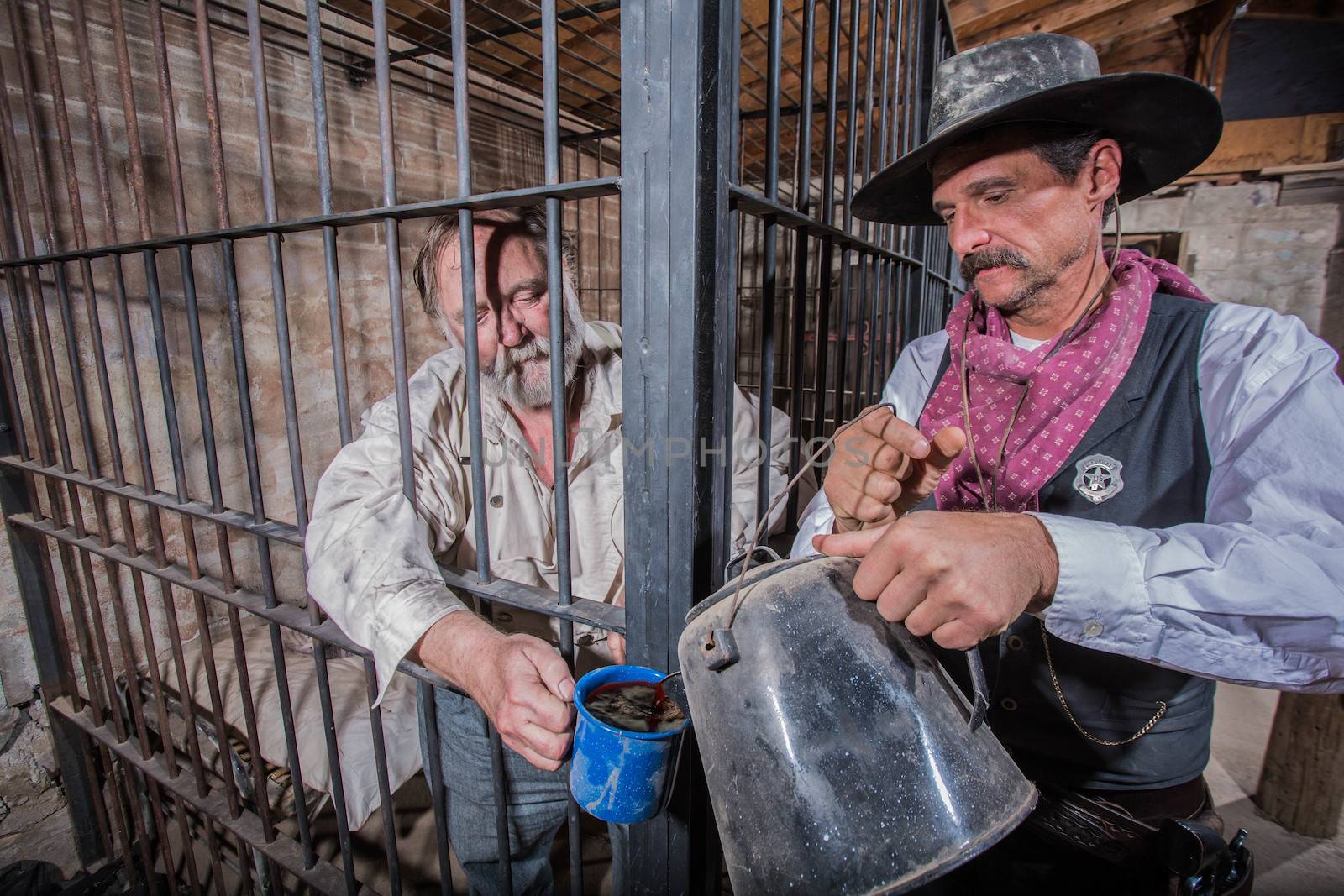 Sheriff Tends to a Prisoner In a Cell