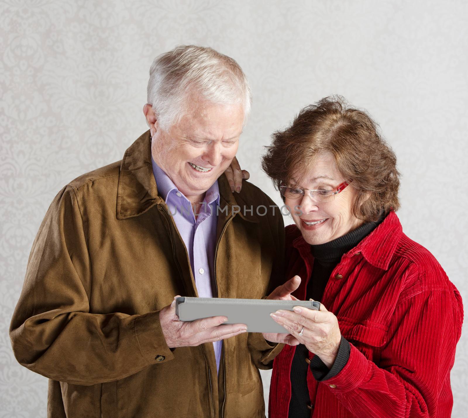 Senior male and female excited with computer tablet