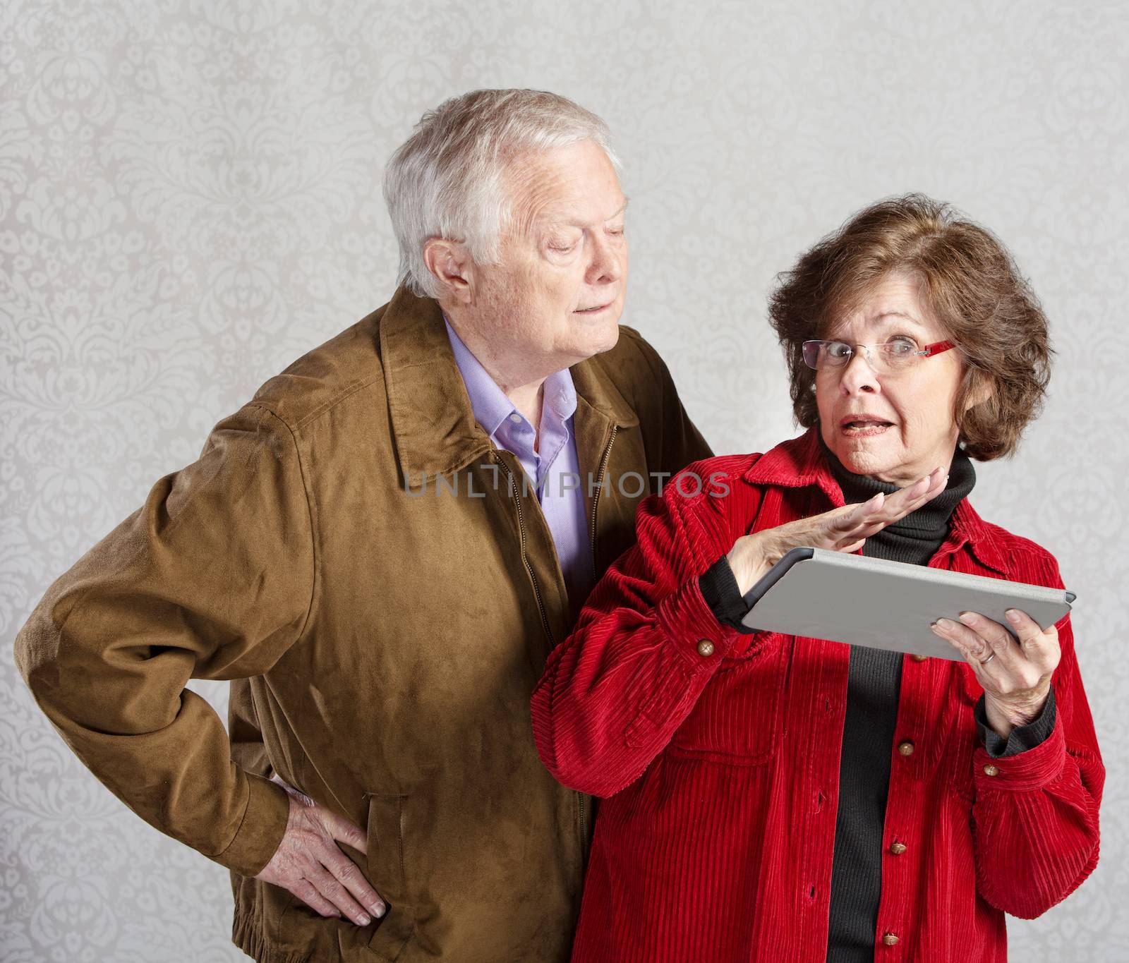 Suspicious man looking over shoulder of woman with tablet